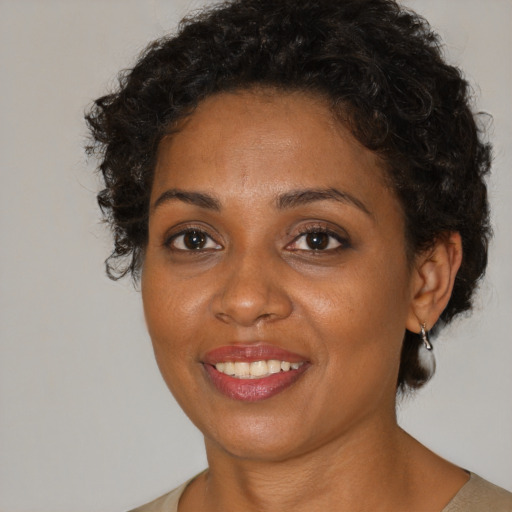 Joyful black adult female with short  brown hair and brown eyes