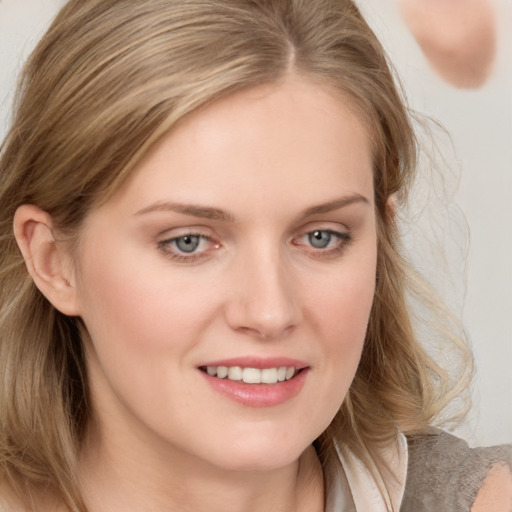 Joyful white young-adult female with medium  brown hair and blue eyes