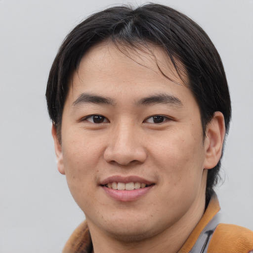 Joyful asian young-adult male with medium  brown hair and brown eyes