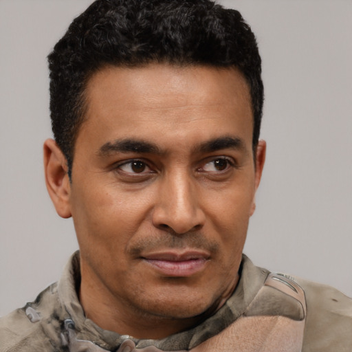 Joyful latino young-adult male with short  brown hair and brown eyes