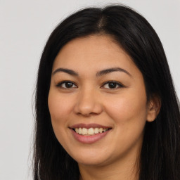 Joyful latino young-adult female with long  brown hair and brown eyes