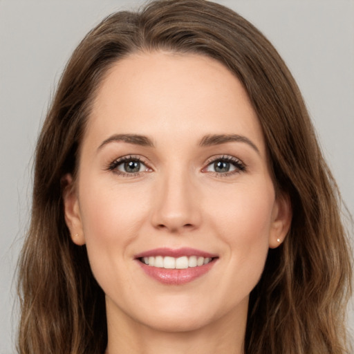 Joyful white young-adult female with long  brown hair and brown eyes