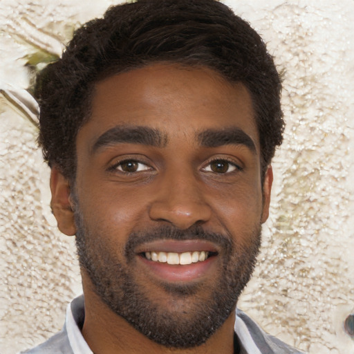 Joyful black young-adult male with short  black hair and brown eyes