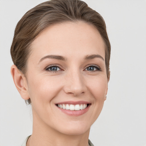 Joyful white young-adult female with short  brown hair and grey eyes