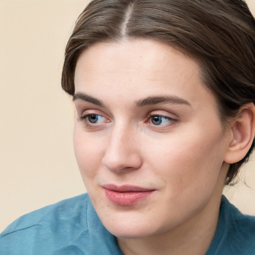 Joyful white young-adult female with medium  brown hair and blue eyes