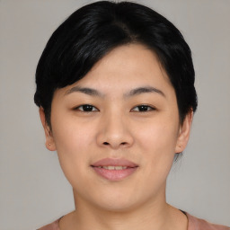 Joyful asian young-adult female with short  black hair and brown eyes