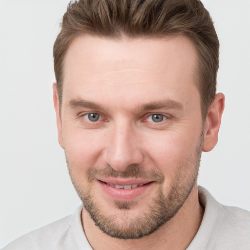 Joyful white young-adult male with short  brown hair and grey eyes