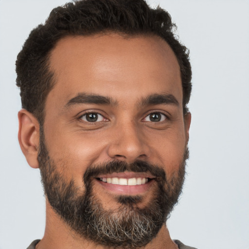 Joyful black young-adult male with short  brown hair and brown eyes