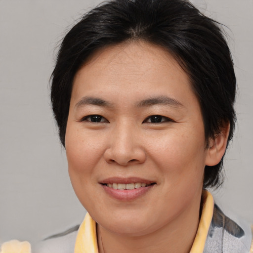 Joyful asian young-adult female with medium  brown hair and brown eyes