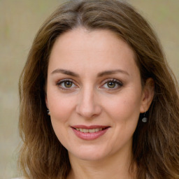 Joyful white young-adult female with long  brown hair and green eyes