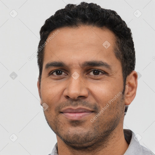 Joyful latino adult male with short  black hair and brown eyes