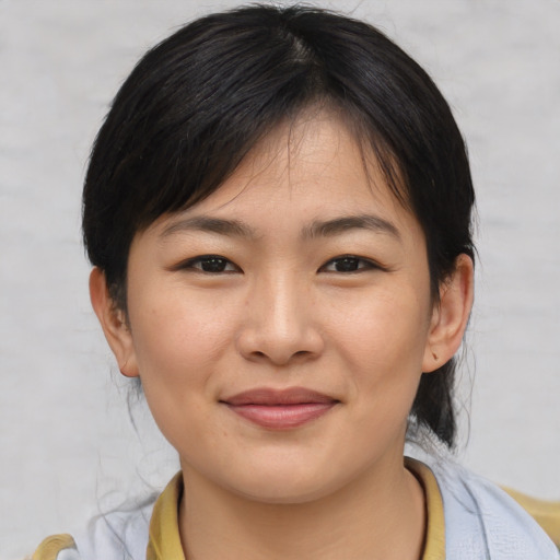 Joyful asian young-adult female with medium  brown hair and brown eyes