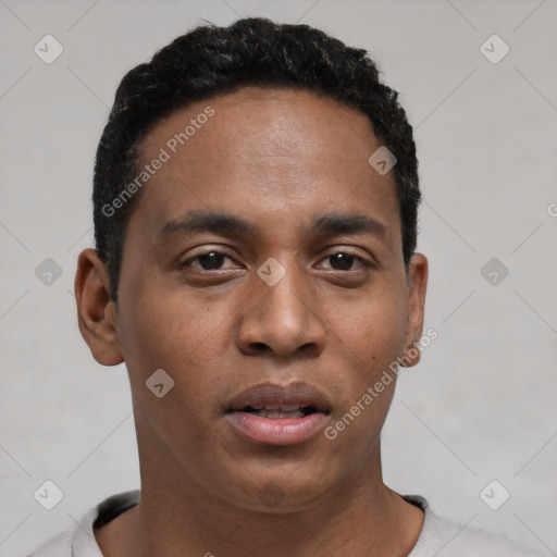 Joyful black young-adult male with short  black hair and brown eyes