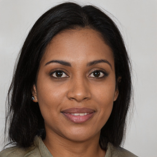 Joyful black young-adult female with long  brown hair and brown eyes
