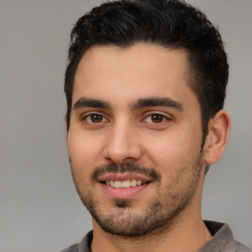 Joyful white young-adult male with short  black hair and brown eyes