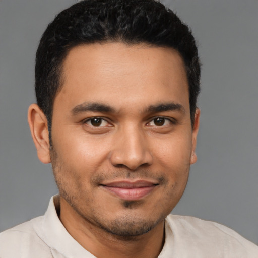 Joyful latino young-adult male with short  brown hair and brown eyes