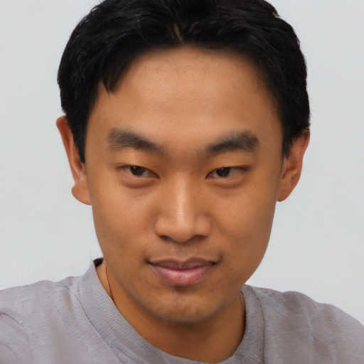 Joyful asian young-adult male with short  black hair and brown eyes