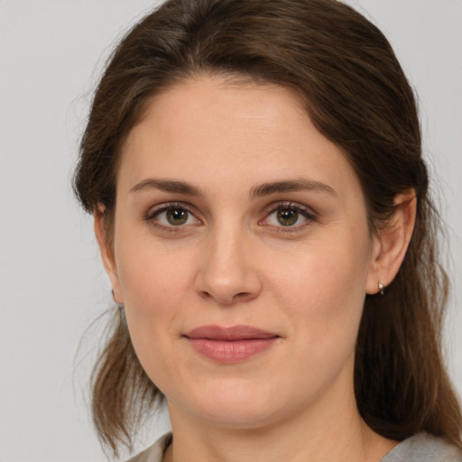 Joyful white young-adult female with medium  brown hair and green eyes