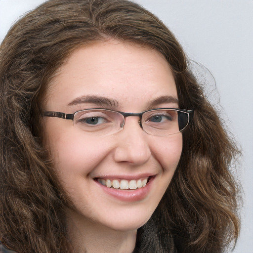 Joyful white young-adult female with long  brown hair and blue eyes