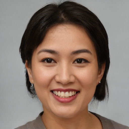 Joyful asian young-adult female with medium  brown hair and brown eyes