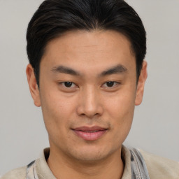 Joyful asian young-adult male with short  brown hair and brown eyes