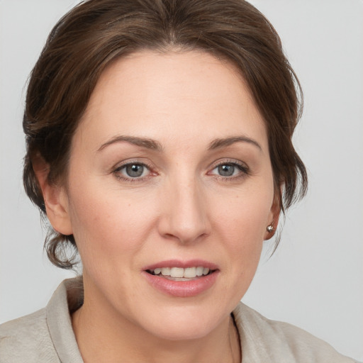 Joyful white young-adult female with medium  brown hair and grey eyes