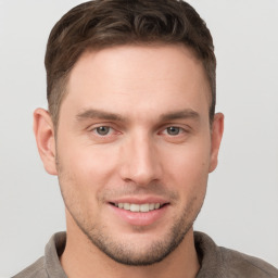 Joyful white young-adult male with short  brown hair and grey eyes