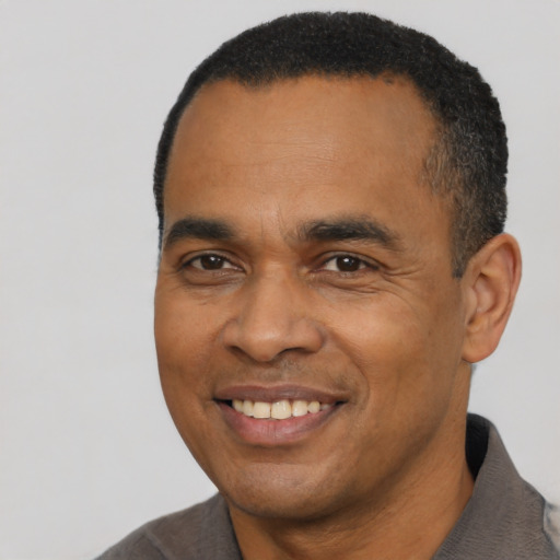 Joyful black adult male with short  black hair and brown eyes