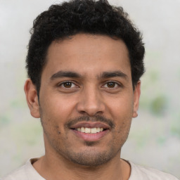 Joyful latino young-adult male with short  brown hair and brown eyes
