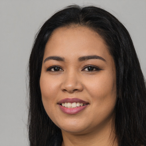 Joyful latino young-adult female with long  black hair and brown eyes