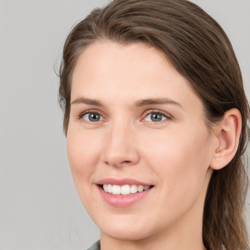 Joyful white young-adult female with long  brown hair and grey eyes