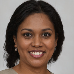 Joyful black adult female with medium  brown hair and brown eyes