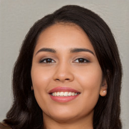 Joyful latino young-adult female with long  brown hair and brown eyes