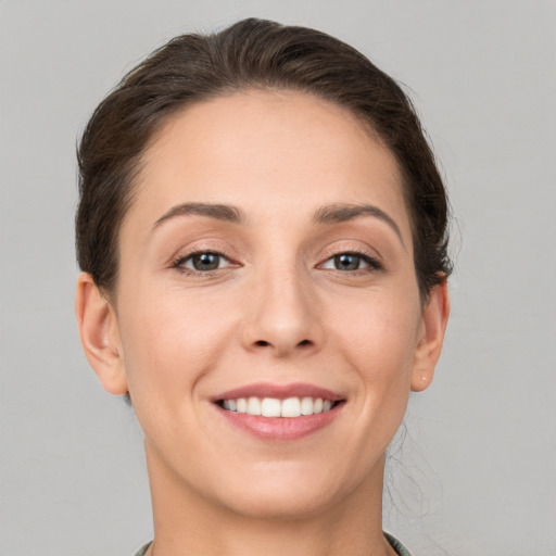 Joyful white young-adult female with short  brown hair and grey eyes