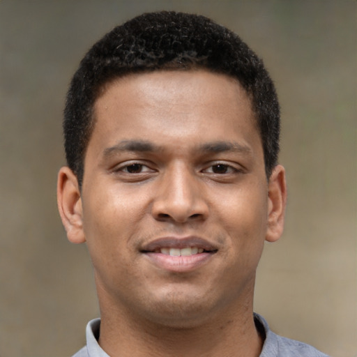 Joyful black young-adult male with short  brown hair and brown eyes