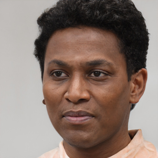 Joyful black young-adult male with short  brown hair and brown eyes