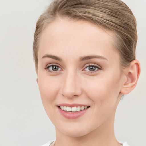 Joyful white young-adult female with medium  brown hair and grey eyes