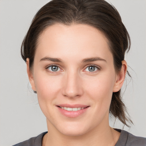 Joyful white young-adult female with medium  brown hair and grey eyes