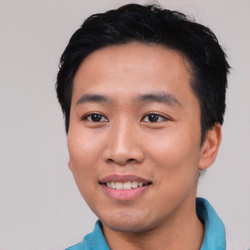 Joyful asian young-adult male with short  black hair and brown eyes