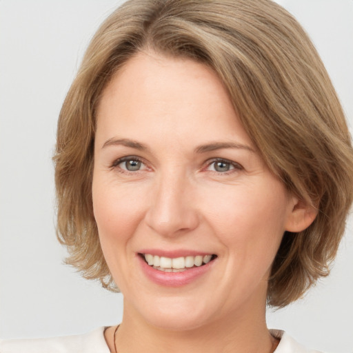 Joyful white adult female with medium  brown hair and grey eyes