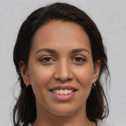 Joyful latino young-adult female with long  brown hair and brown eyes