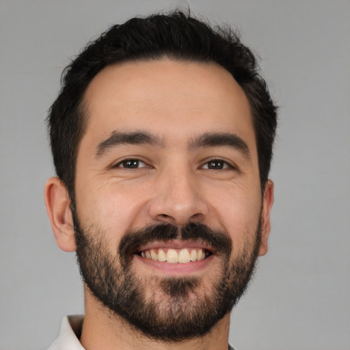 Joyful white young-adult male with short  black hair and brown eyes