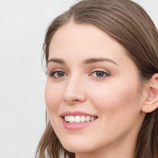 Joyful white young-adult female with long  brown hair and blue eyes