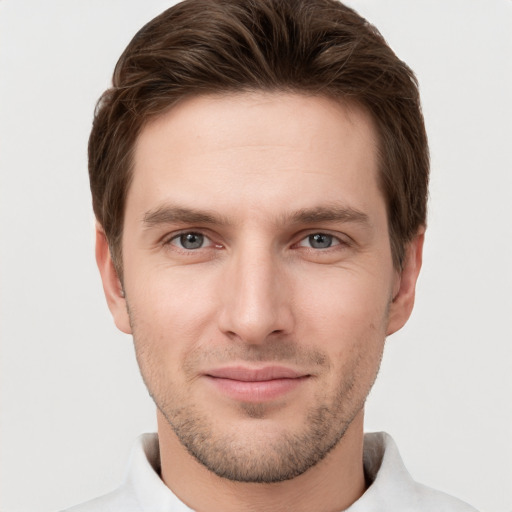 Joyful white young-adult male with short  brown hair and grey eyes