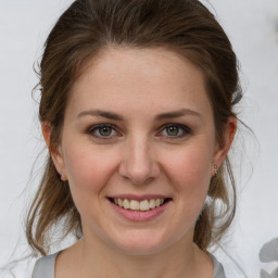 Joyful white young-adult female with medium  brown hair and grey eyes