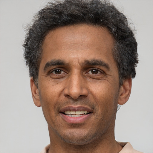 Joyful latino adult male with short  black hair and brown eyes