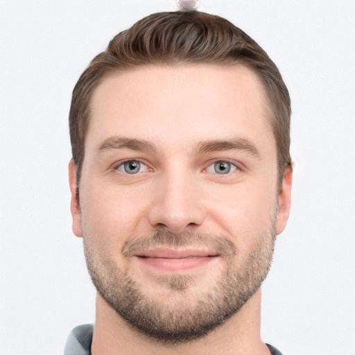 Joyful white young-adult male with short  brown hair and grey eyes