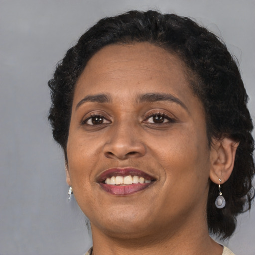 Joyful black adult female with medium  brown hair and brown eyes