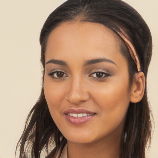 Joyful latino young-adult female with long  brown hair and brown eyes