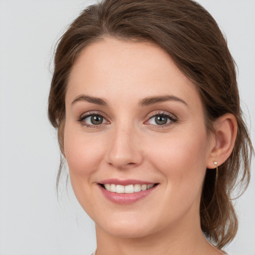 Joyful white young-adult female with medium  brown hair and green eyes